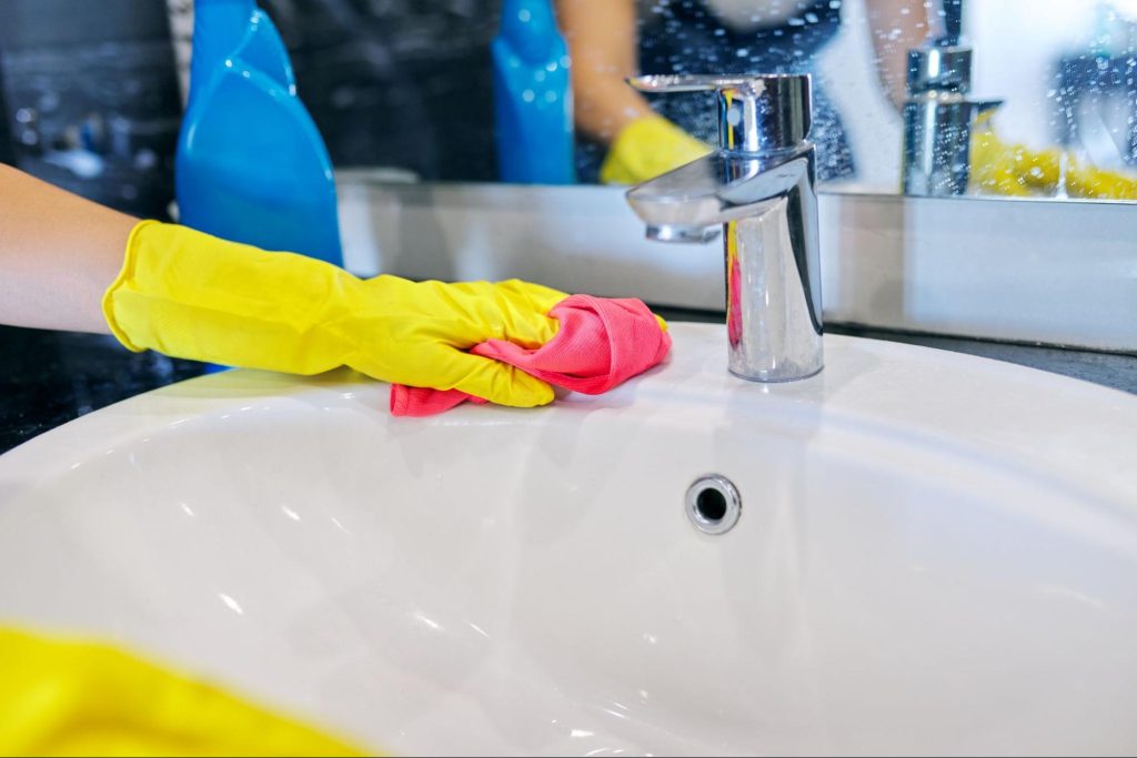 Employee cleaning washroom in commercial business