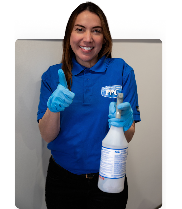 Smiling commercial cleaner from Picture Perfect Cleaning giving a thumbs-up while holding a disinfectant spray in Calgary or Edmonton.