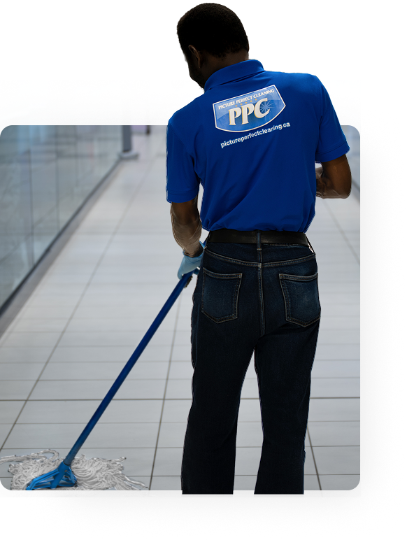 Professional janitor from Picture Perfect Cleaning mopping a mall floor in Calgary or Edmonton.